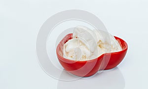 Ice cream melts in a red saucer in the shape of a heart