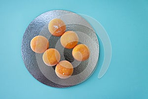 Ice-cream Mochi with mango, traditional japonese rise desert. Orange on pastel blue