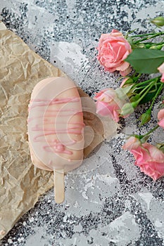 Ice cream pops cake on gray background along with flowers. Selective focus, copy space