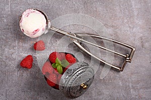 Ice cream scoop with berry ice cream and raspberry on old wooden background