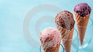 Ice cream scoops in cones with copy space on blue