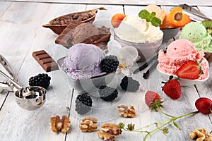 Ice cream scoops of different colors and flavours with berries, nuts and fruits decoration on white background