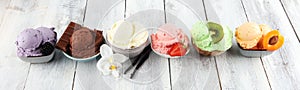 Ice cream scoops of different colors and flavours with berries, nuts and fruits decoration on white background