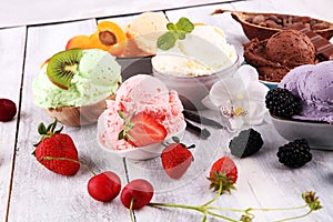 Ice cream scoops of different colors and flavours with berries, nuts and fruits decoration on white background