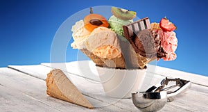 Ice cream scoops of different colors and flavours with berries, nuts and fruits decoration on white background