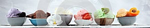 Ice cream scoops of different colors and flavours with berries, nuts and fruits decoration on white background