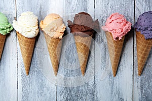 Ice cream scoops of different colors and flavours with berries, nuts and fruits decoration on white background