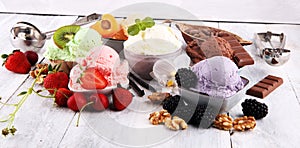 Ice cream scoops of different colors and flavours with berries, nuts and fruits decoration on white background