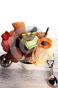 Ice cream scoops of different colors and flavours with berries, nuts and fruits decoration on white background