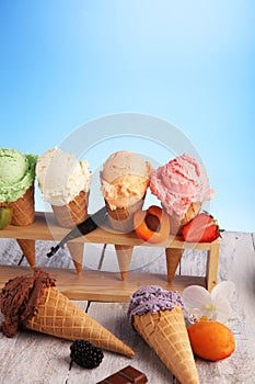 Ice cream scoops of different colors and flavours with berries, nuts and fruits decoration on white background