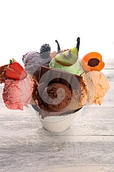 Ice cream scoops of different colors and flavours with berries, nuts and fruits decoration on white background