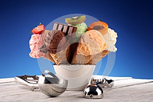 Ice cream scoops of different colors and flavours with berries, nuts and fruits decoration on white background