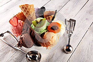 Ice cream scoops of different colors and flavours with berries, nuts and fruits decoration on white background