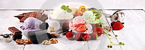 Ice cream scoops of different colors and flavours with berries, nuts and fruits decoration on white background