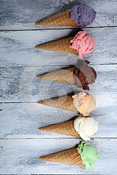 Ice cream scoops of different colors and flavours with berries, nuts and fruits decoration on white background