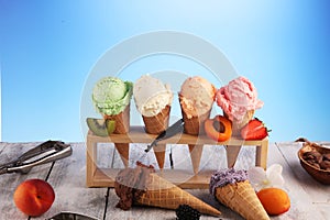 Ice cream scoops of different colors and flavours with berries, nuts and fruits decoration on white background