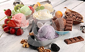 Ice cream scoops of different colors and flavours with berries, nuts and fruits decoration on white background