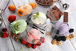 Ice cream scoops of different colors and flavours with berries, nuts and fruits decoration on white background