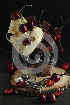 Ice cream scoops in an ice cream bowl with chocolate and cherry