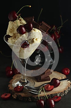 Ice cream scoops in an ice cream bowl with chocolate and cherry