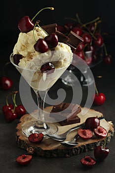 Ice cream scoops in an ice cream bowl with chocolate and cherry