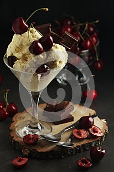 Ice cream scoops in an ice cream bowl with chocolate and cherry