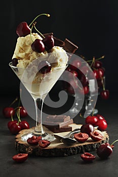 Ice cream scoops in an ice cream bowl with chocolate and cherry