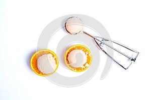 Ice cream scoops on a orange fruit