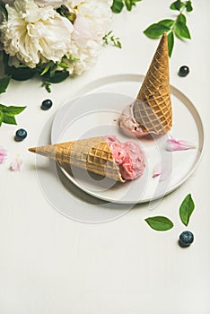 Ice cream scoops and peonies over white background, copy space