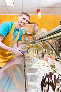 Ice cream seller in his shop at the counter