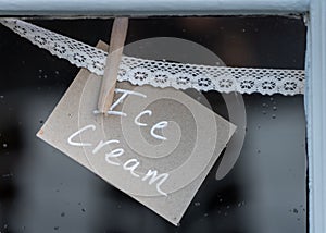 Ice cream sign pegged to lace in shop window
