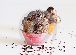 Ice cream in small pink wafer cup on white with chocolate sprinkles - space for text