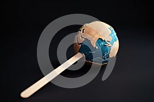 Ice cream stick in the form of planet earth, concept of Global warming, created with Generative AI technology