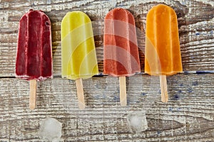 Ice cream on a stick with fruits on the light wooden table