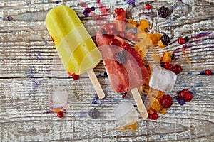 Ice cream on a stick with fruits on the light wooden table