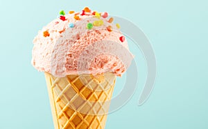 Ice cream. Strawberry or raspberry flavor icecream in waffle cone over blue background