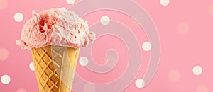 Ice cream. Strawberry or raspberry flavor icecream in waffle cone over pink polka dots background photo