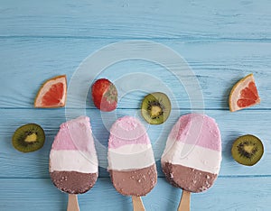 Ice cream summer fruits dessert fresh rustic flavor on a blue wooden background, grapefruit, lemon, kiwi, pattern, strawberry