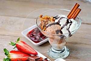 Ice cream sundae, chocolate, walnuts, sliced strawberry and cherry jam