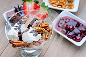 Ice cream sundae, chocolate, walnuts, sliced strawberry and jam