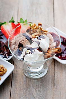 Ice cream sundae, chocolate, walnuts, sliced strawberry and jam