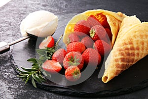 Ice cream vanilla flavor and cones with fresh strawberry setup o