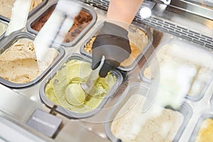 An ice cream vendor makes an ice cream ball. Flavors various ice cream in Rome, Italy. Italian gelateria. Natural fresh
