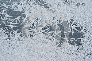 Ice crystals forming spike shapes on frozen river, closeup macro detail