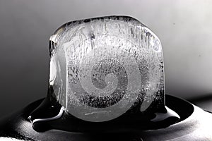 Ice cube on black background. Low key photo