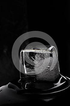 Ice cube on black background. Low key photo