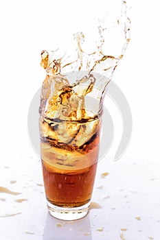 Ice cube droped in cola glass