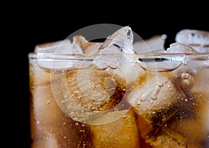 Ice cube in fizzy splashing water with soda