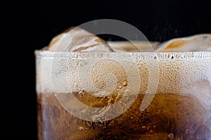 Ice cube in fizzy splashing water with soda