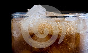 Ice cube in fizzy splashing water with soda